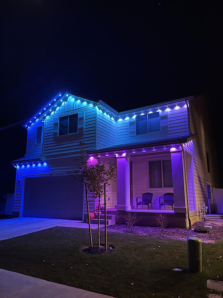 Blue and purple permanent lighting along a home's gables and porch