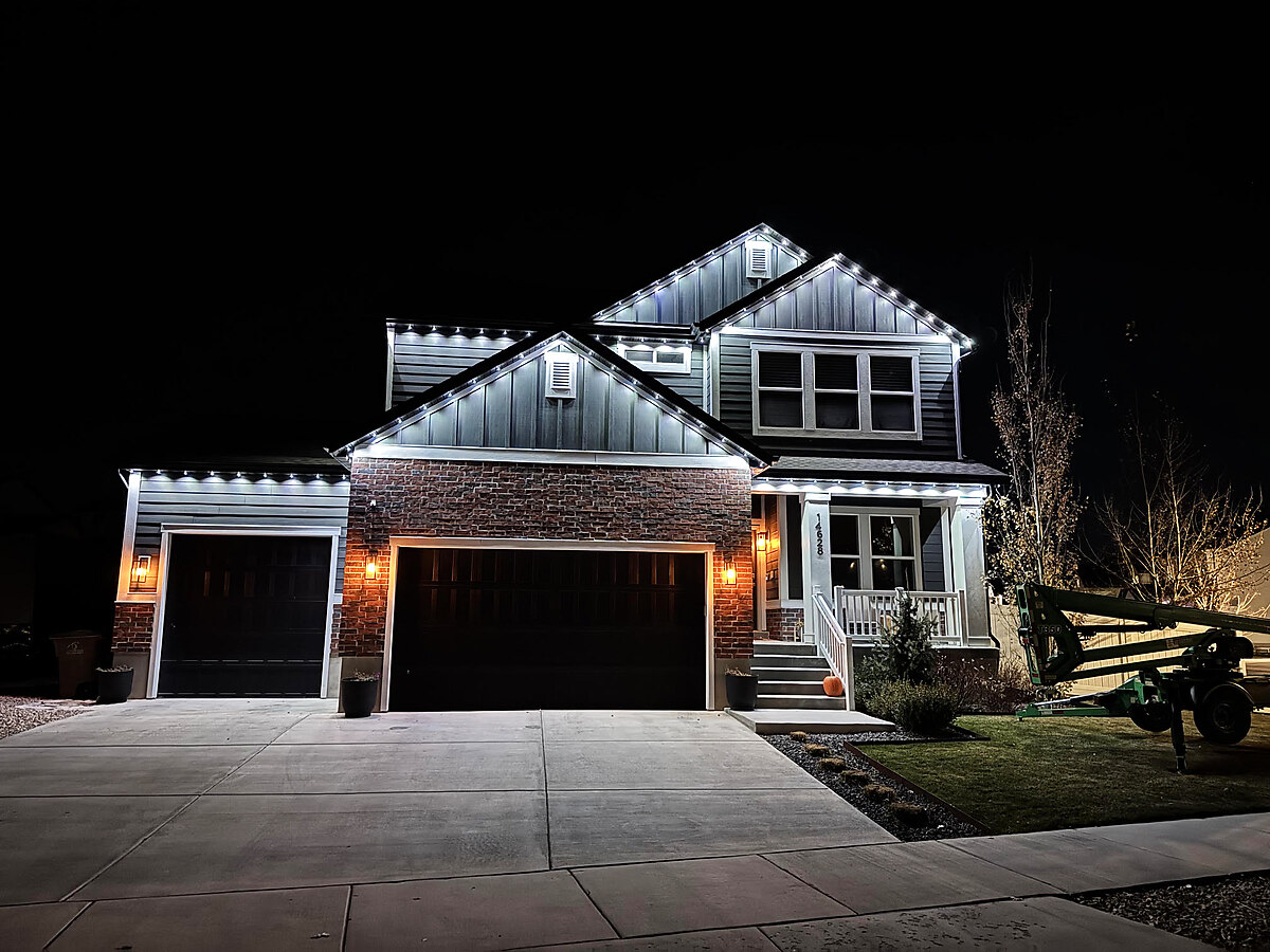 Warm white permanent lighting outlining a home's rooflines