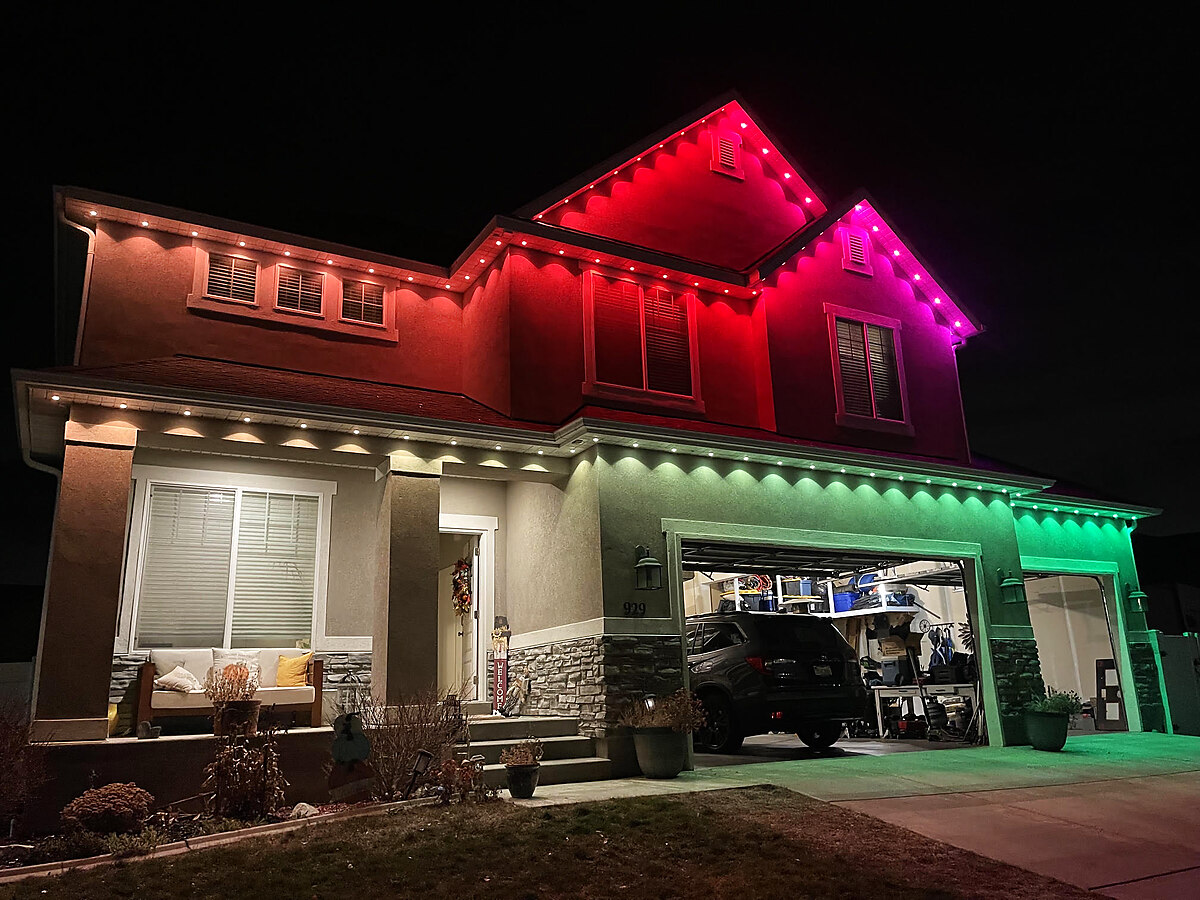 Red and green permanent lighting on a two-story home