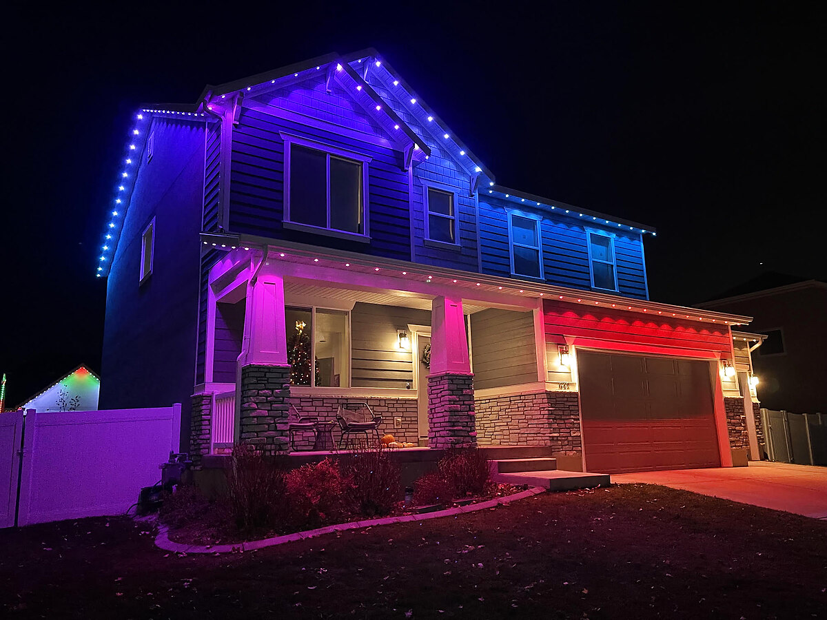 Purple, blue, and red permanent lighting on a craftsman-style home